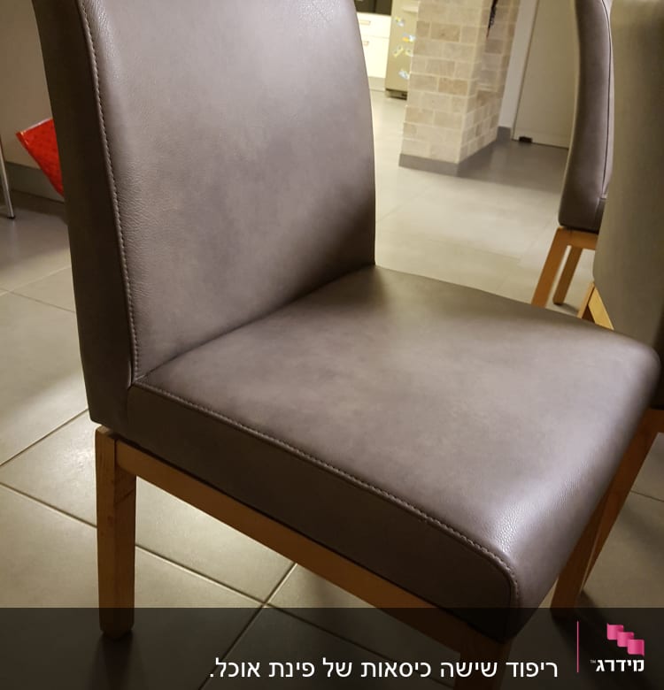 כיסא מרופד עם רגלי עץ על רצפת אריחים